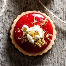 Top down look of shortbread cookie with lemon berry jam and a piece of popcorn.