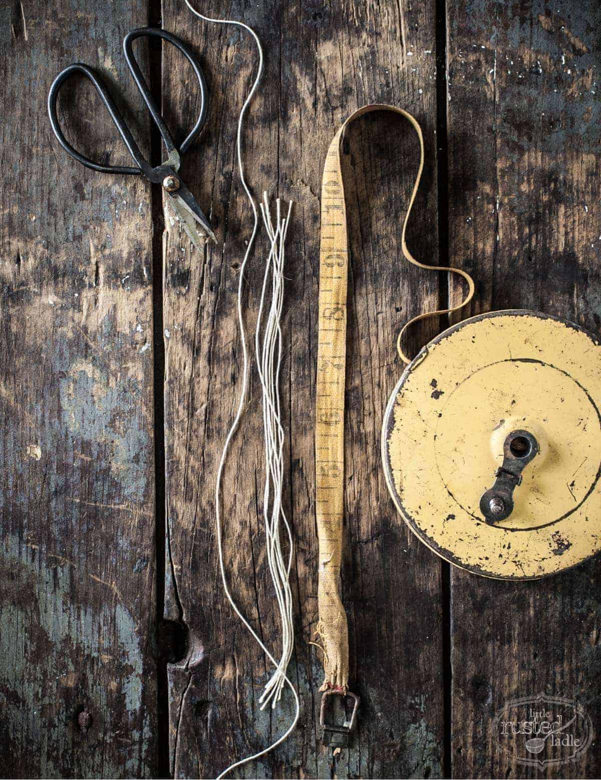 cut string measured out with an antique cloth tape measure on rustic wood