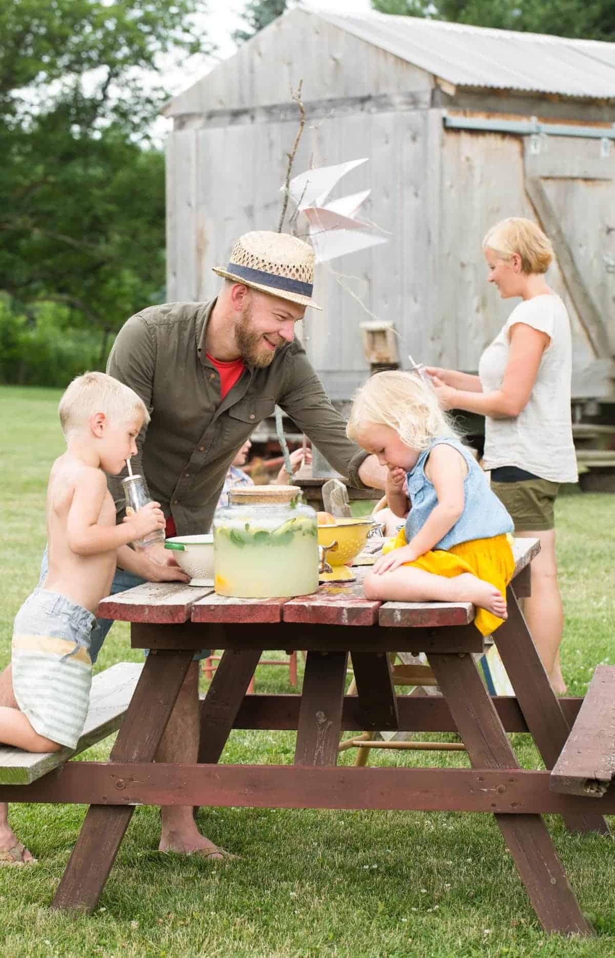 family at a picnic table making lemonade