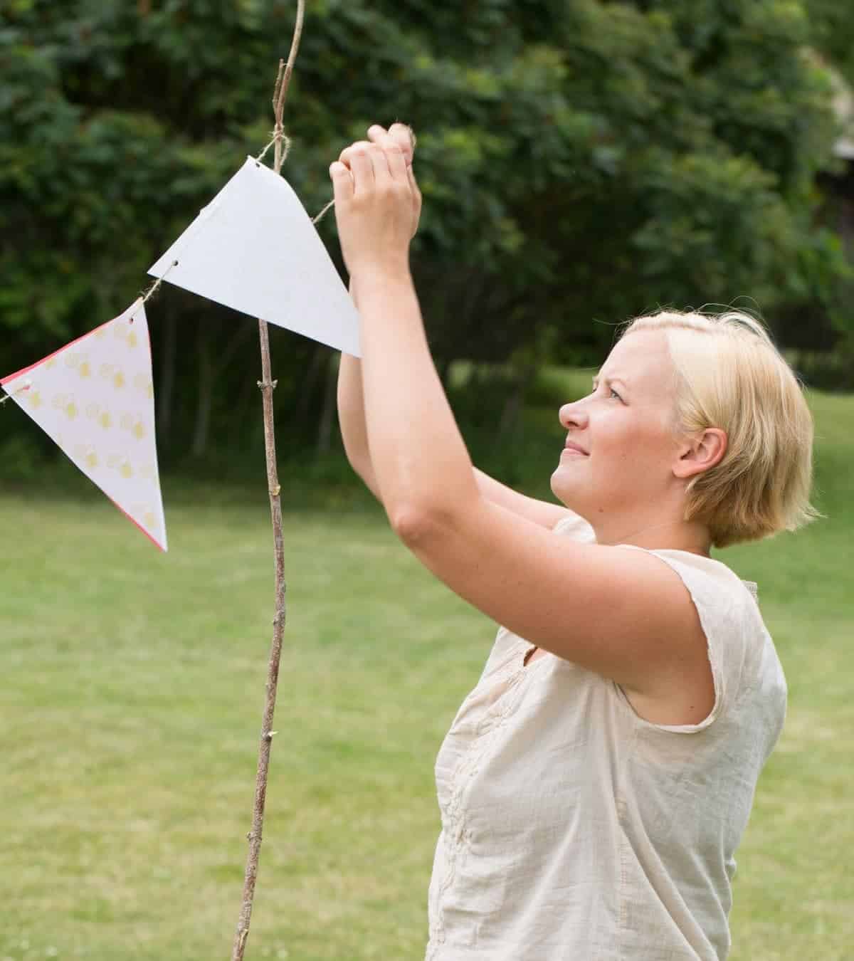 Mom hanging up a pennant banner above the lemonade stand