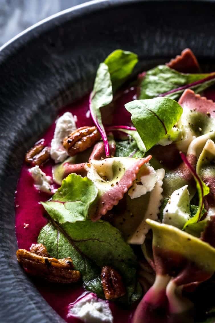 Closeup of healthy 3-beet soup with bowtie noodles and whole pecans