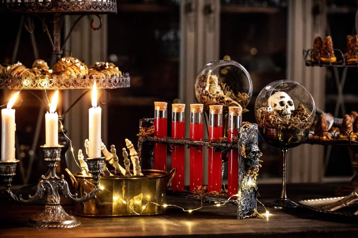 Wide shot of the spooky treat table with DIY decor, candles, and twinkle lights. 