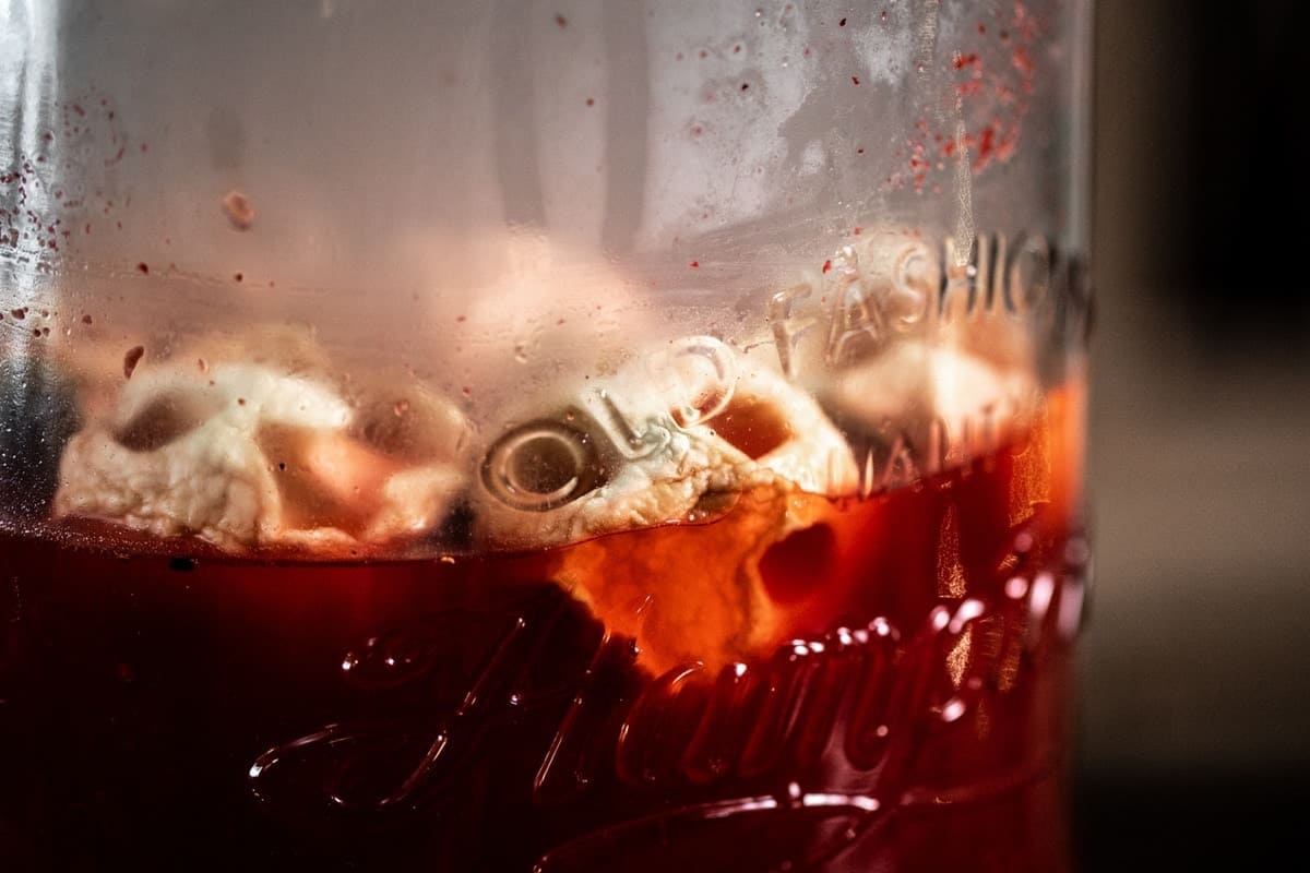 Apple Skulls floating in Old Fashioned from the side