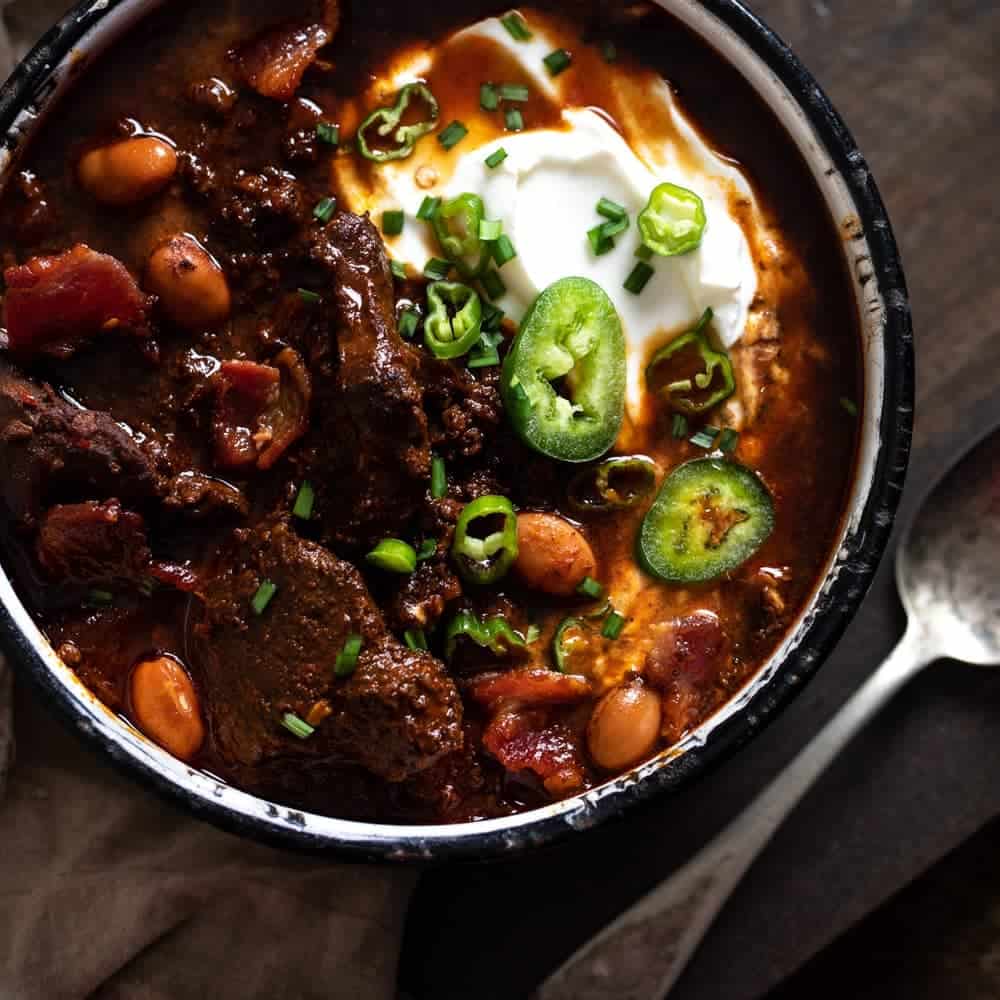 Overhead photo of venison chili with jalapenos and sour cream