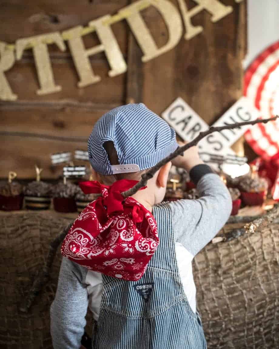 Austin with back to camera holding handkerchief bindle. 