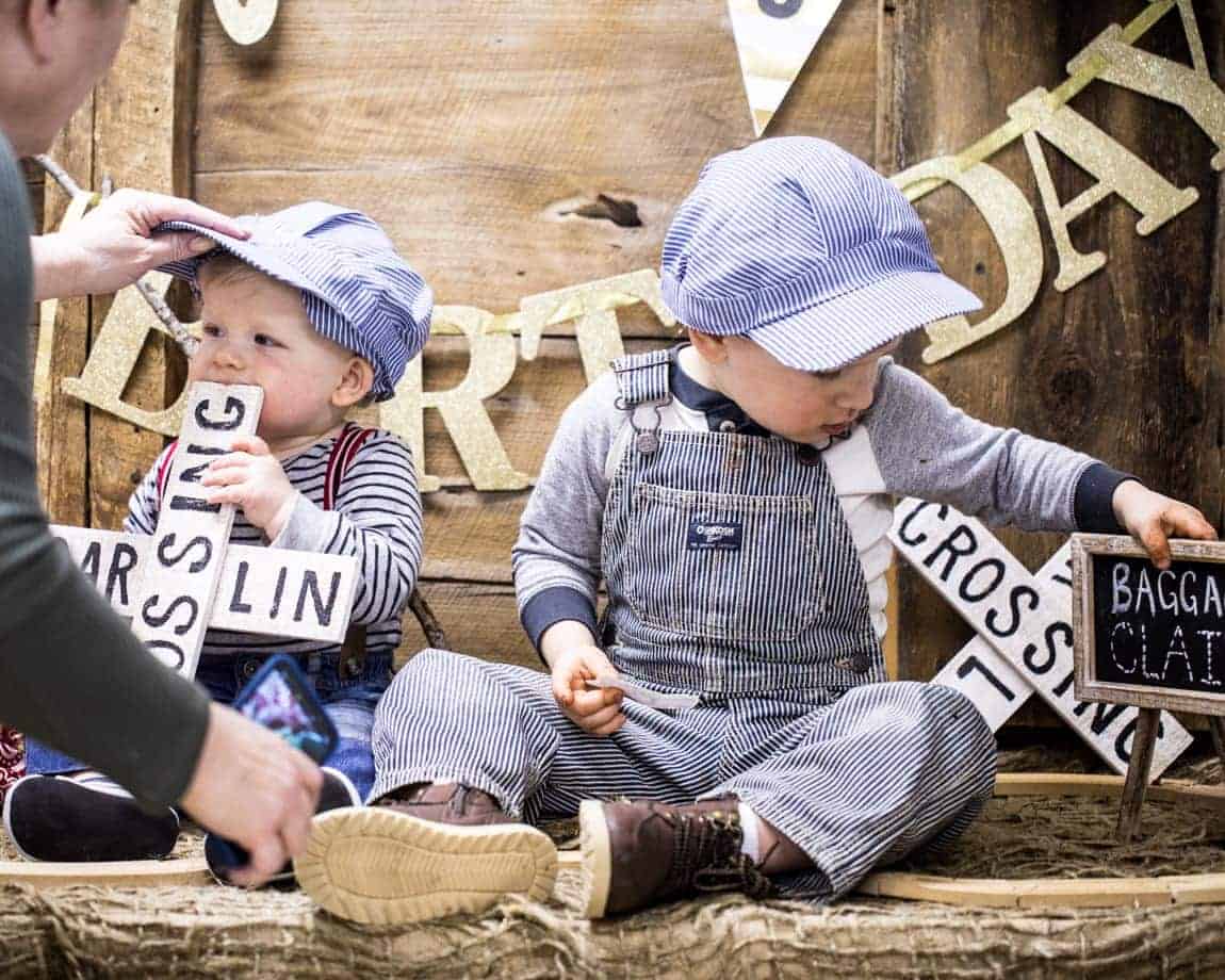 Brothers in striped overalls with train crossing signs