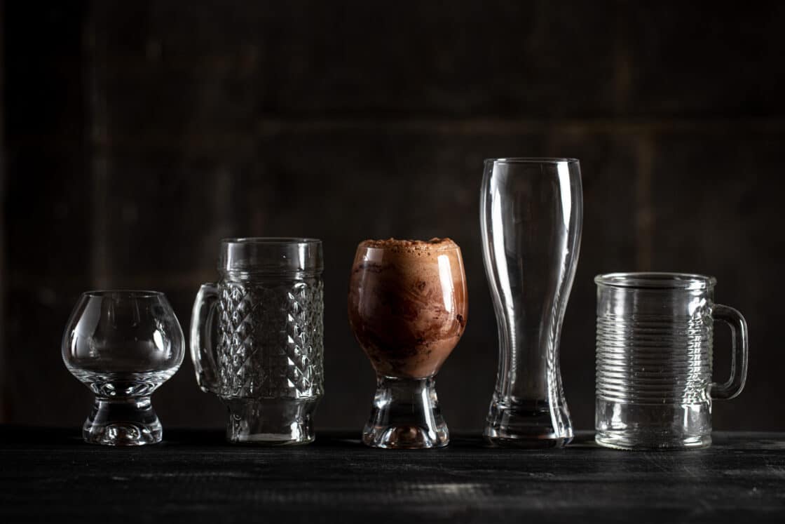 A line of fun glassware with only the center one full. Seeing lighting techniques in commercial drink photography