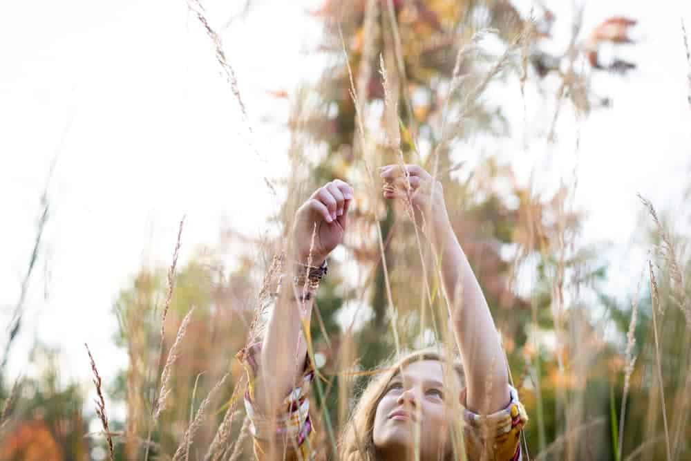 Girl playing in a fall field