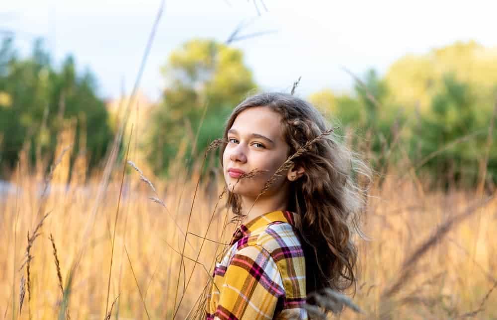 Girl standing in a fall field 