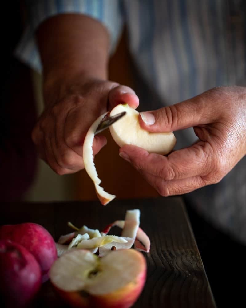 Grandma hands pealing apples with paring knife