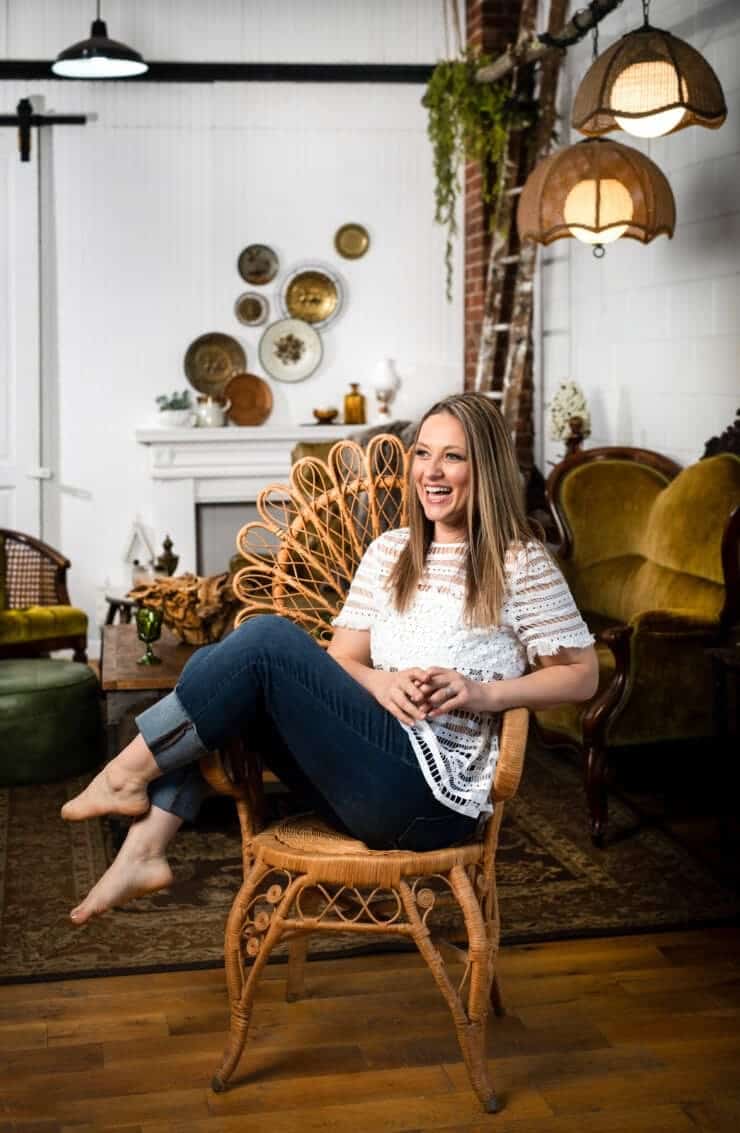 Upbeat Lifestyle branding image of a woman photographer in her bright, Rustic, and inviting studio laughing.