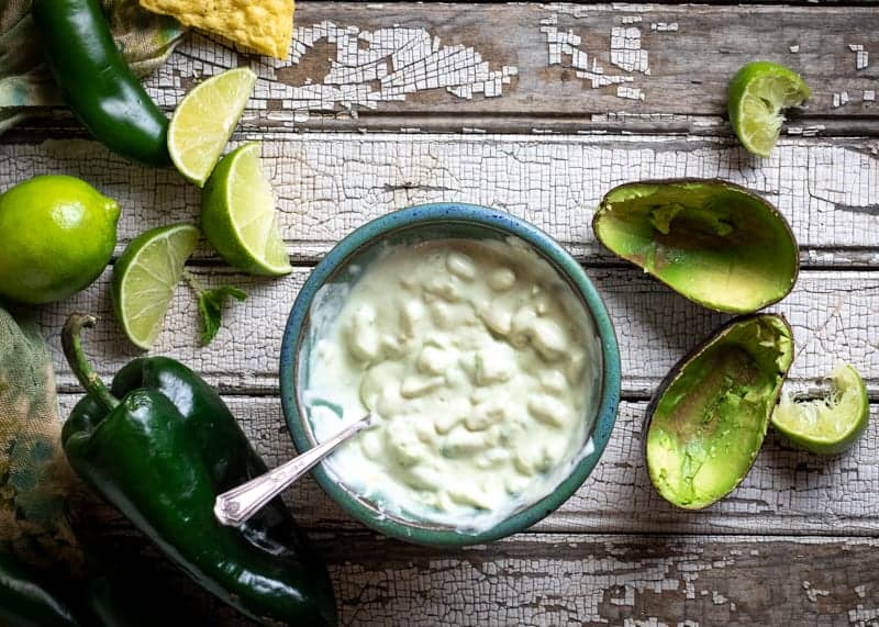 Overhead shot of mixed yogurt and avocado topping with ingredients around.