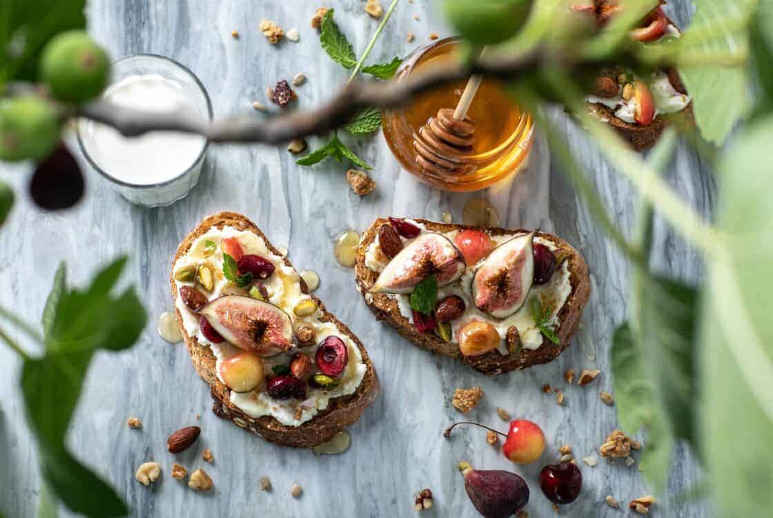 overhead shot with out of focus foreground and fig toast and honey on wooden surface