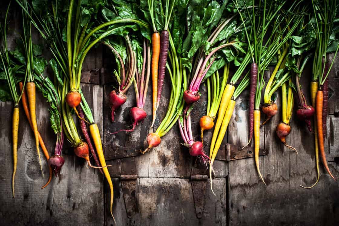 a beautiful spread of colorful root vegetables, beets, carrots