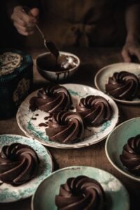 3/4 shot of chocolate desserts on colorful plates with chocolate drizzle.