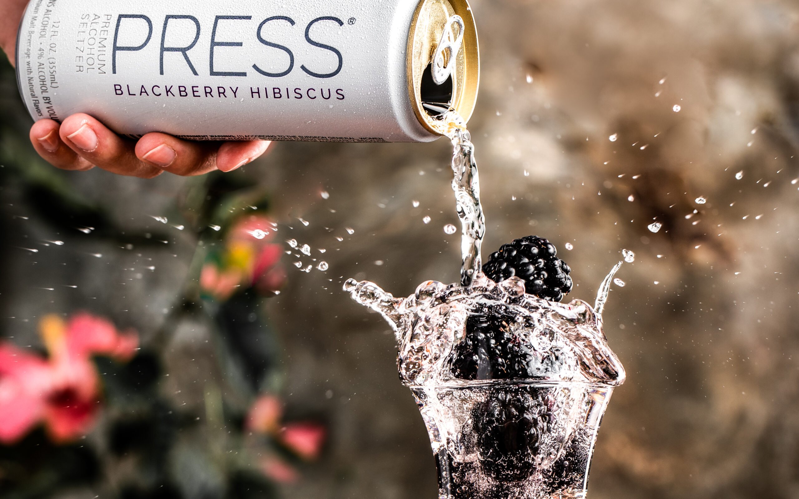 commercial beverage photo splash photo with Press hard seltzer over blackberries