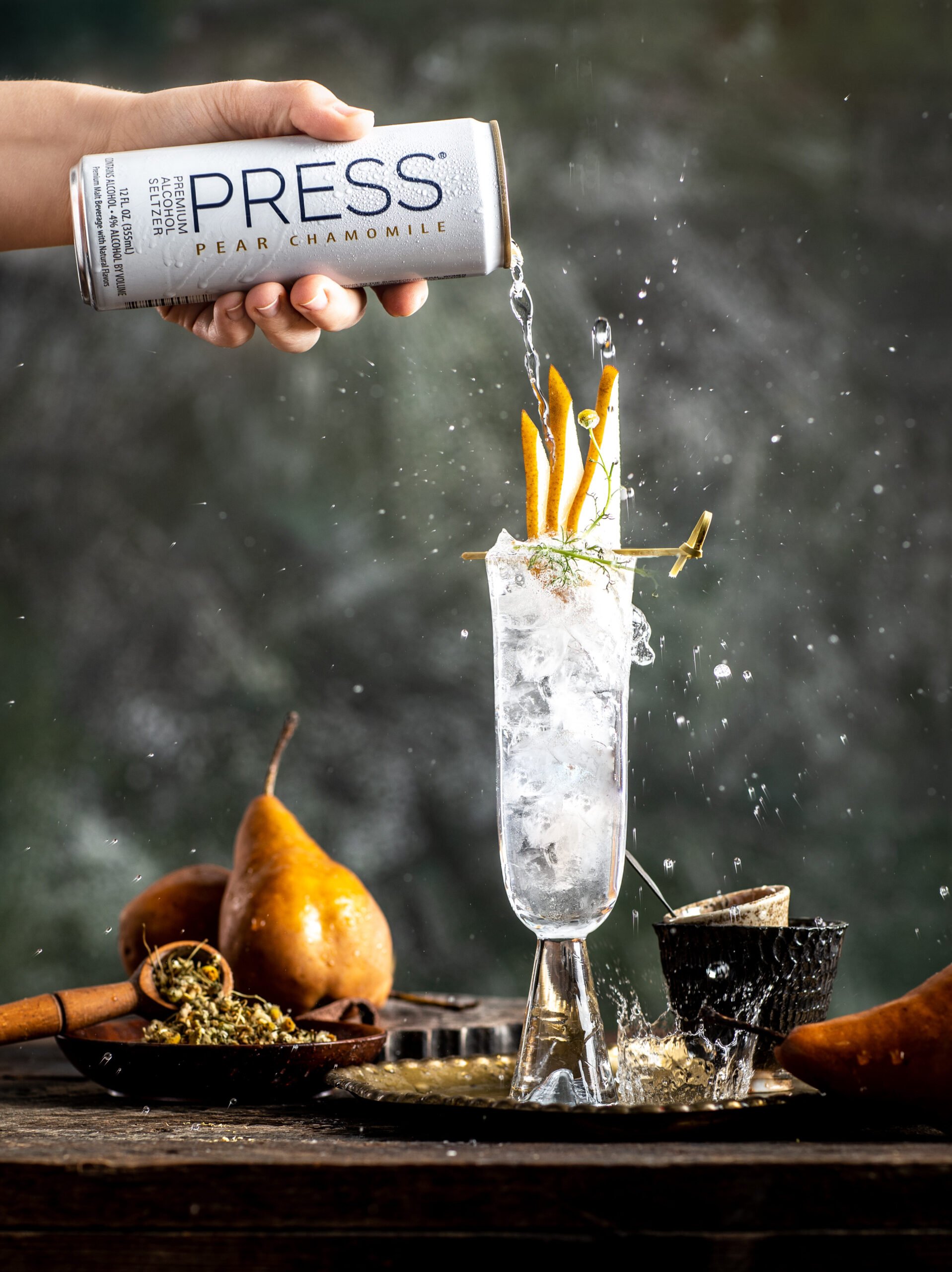 Professional pour and splash photography with can of Press hard seltzer and pear garnish