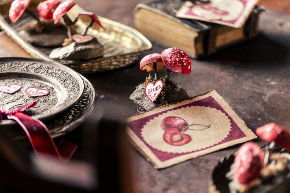 Tablescape showing dried orange peel shaped into red polka-dot mushrooms in a tablescape centerpiece